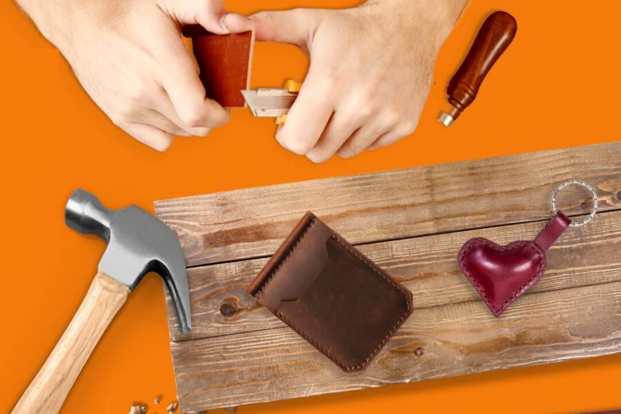 Hammer, hands working with leather tools, wallet, belt, plank of wood