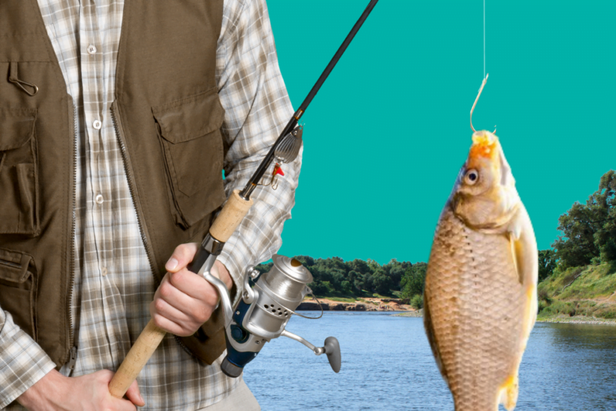 Man holding fishing rod with fish hanging on hook and a kake in the background